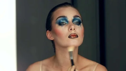 Reflection of young beautiful girl applying her art make-up, looking in a mirror Stock Footage 80614275