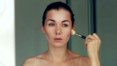 Reflection of young beautiful girl applying her art make-up, looking in a mirror Video stock 80729336