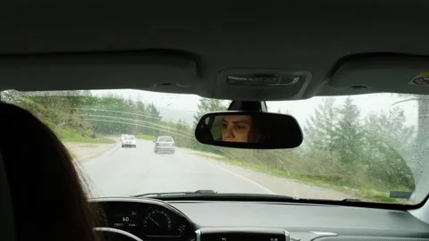 Reflection of young woman's face in rearview car mirror. Stock Footage 250173086