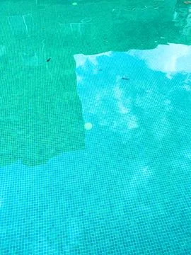 Reflections and ripples create patterns in water of a swimming pool on a su.. Stock Photos