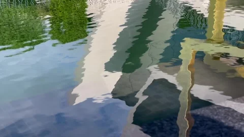 Reflections of angular art objects in a rippling urban pond Stock Footage 295368840