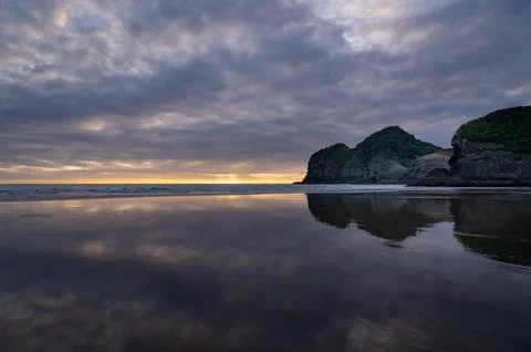 Reflections at the Bethells Beach at sunset Stock Photos