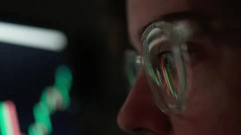 Reflections of the chart of crypto currency in glasses the eyes of a trader Stock Footage 211420319
