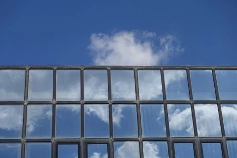 Reflections clouds and blue sky on building windows Fotos de archivo