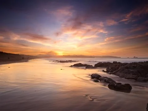 Reflections of the clouds on the beach of Liencres Stock Photos