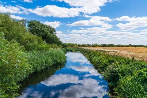 Reflections of the clouds in the sky in the River Anker in Tamworth, UK Фото