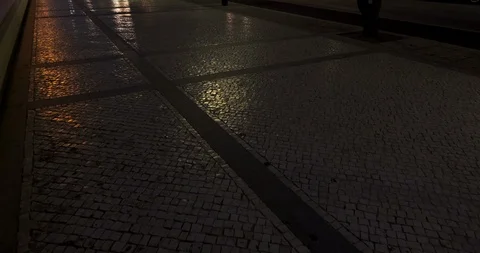 Reflections of colored lights and moving shadows on Portuguese sidewalk at night Stock Footage 116361739