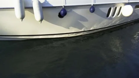 Reflections dance on the side of a yacht on the background of waves close-up Stock Footage 85020361