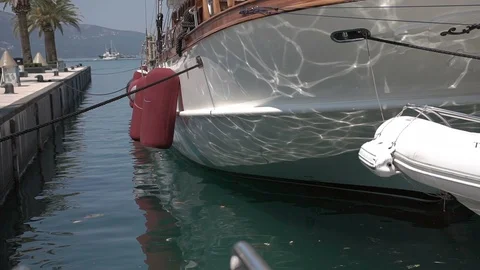 Reflections dance on the side of a yacht on the background of waves close-up Stock Footage 96128198