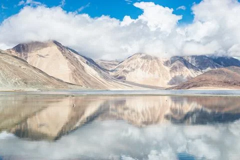 Reflections of high mountain with white cloud and blue sky on the Pagong lake Stock Photos
