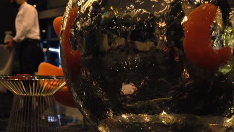 Reflections in a large metallic glitter ball in an atrium Stock Footage 158924609