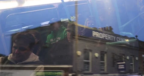 Reflections of London bus passengers over evening city rooftops Stock Footage 321016285