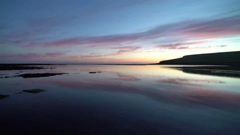 Reflections on the  marwick shore with kitchener's memorial in Orkney in 4k Stock Footage 298276111