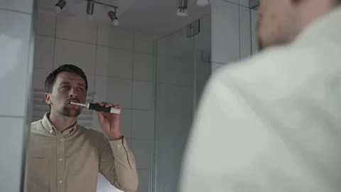 Reflections in mirror, man in shirt before work brushes his teeth with black Stock Footage 291902166