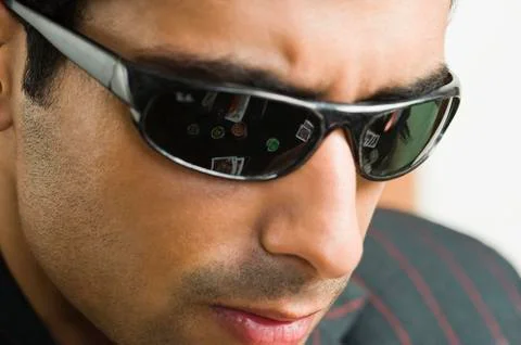 Reflections of playing cards and gambling chips in the goggles worn by a man in Stock Photos