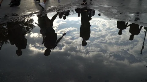 Reflections on puddle and legs of the walking people Stock Footage 115905241