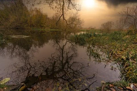 Reflections in a river with a dramatic sunset in the background. Picture from Stock Photos