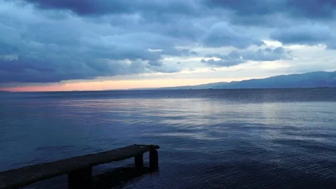 Reflections on the sea surface at evening sunset. Dock and sea. Calm environment Stock Footage 223578275