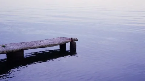 Reflections on the sea surface at evening sunset. Dock and sea. Tranquility Stock Footage 225501003