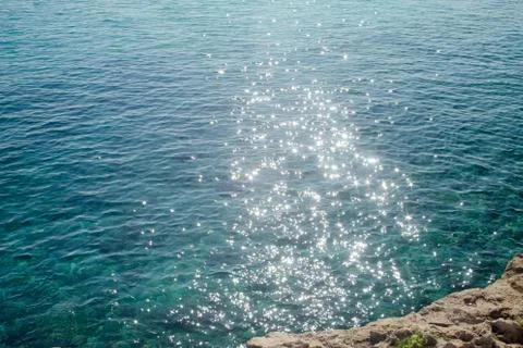Reflections of the sun on the sea from the rocks Stock Photos