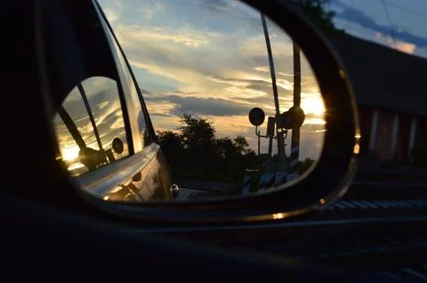 Reflections of a sunset in a car mirror showcasing vibrant colors and serene Stock Photos
