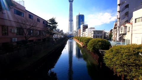 Reflections of the Tokyo Skytree, the North Jukken River, and Sunbeams Through Видео 330250034
