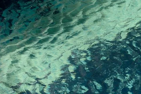 Reflections of tranquility dancing on the surface of clear blue waters at m.. Stock Photos