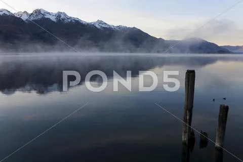 Reflections in the water of the richardson mountains at sunrise at lake wakat Stock Photos