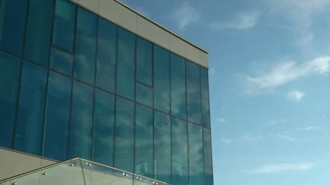 Reflective building facade under clear sky with modern glass railing in Stock Footage 254547486