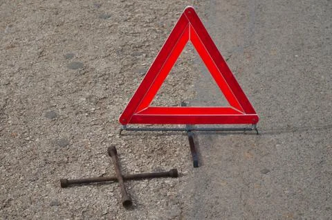 Reflective car warning triangle and tool on the road Foto stock