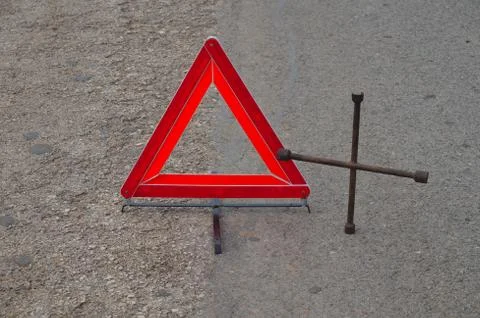 Reflective car warning triangle and tool on the road Stock Photos