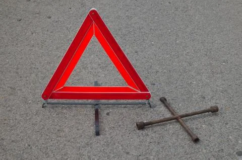 Reflective car warning triangle and tool on the road Stock Photos