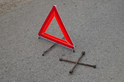 Reflective car warning triangle and tool on the road Stock Photos