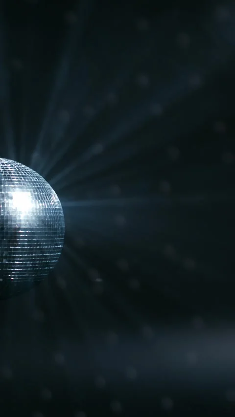 Reflective disco ball rotating with blue light rays and floating dust particles Stock Footage 347734708