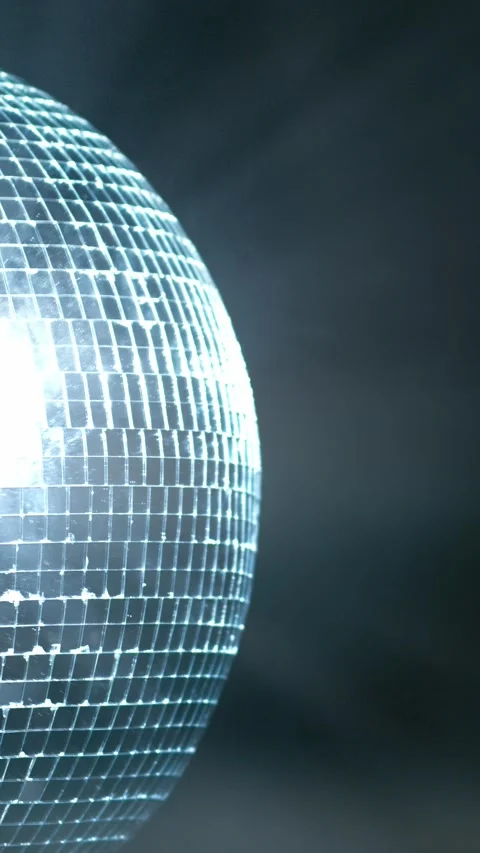 Reflective disco ball rotating slowly against a dark smoky background with Stock Footage 347734776