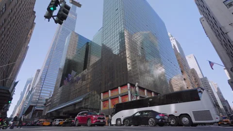 Reflective glass skyscraper with traffic moving along busy Manhattan city street Stock-Footage 321272649