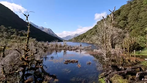 A reflective Lake Howden surrounded by mountains on Routeburn Track, Fiordl.. Stock Footage 295248797
