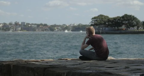 Reflective Man Sits Alone on Pier 库存影片 86221431
