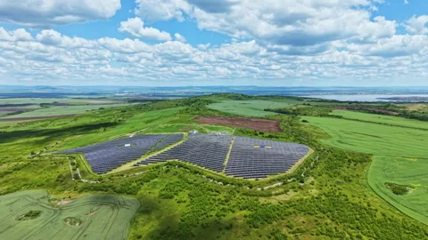 Reflective panels on rolling terrain. Contemporary solar array over peaceful Video stock 337919792