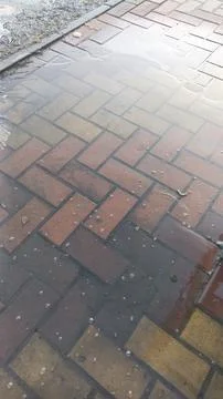 Reflective Puddle on Brick Pavement A Study in Texture and Urban Landscape Stock Photos