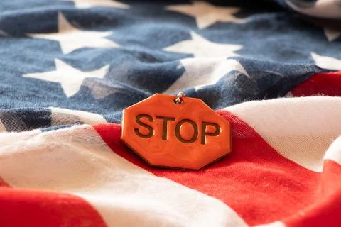Reflective sign with the text stop which lies on the American flags Stock Photos