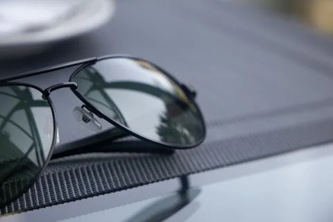 A reflective sunglasses lying on a table Stock Photos