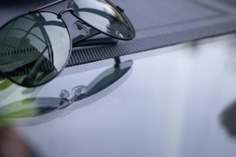 A reflective sunglasses lying on a table Stock Photos