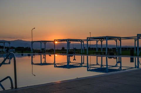 Reflective sunset over tranquil poolside retreat in serene landscape Stock Photos