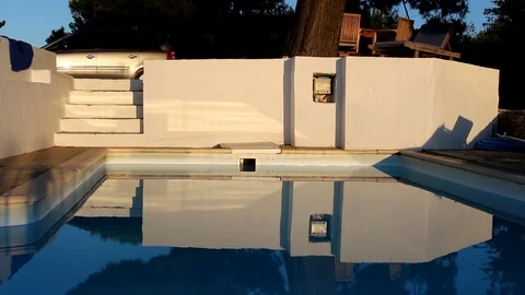 Reflective swimming pool in the evening sunlight, static shot Stock Footage