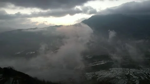 Reflective Terraces Beneath Dramatic Clouds in Yuanyang, China Stock Footage 344038237