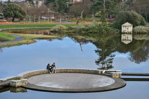Reflective view of circular bridge over pond in Blackrock Park Foto stock