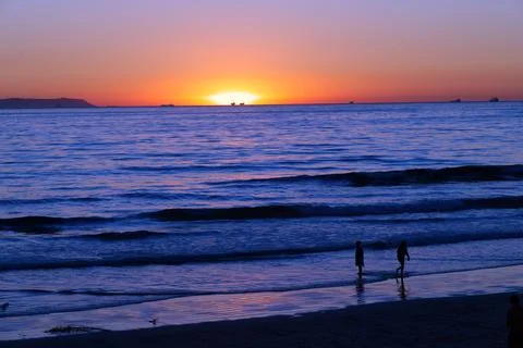 Reflective Waves Between Silhouettes &amp; Sunset Stock Photos