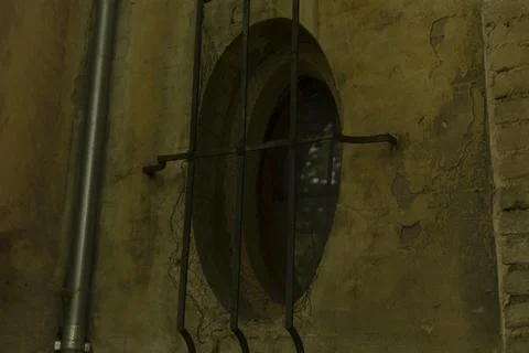 Reflective window beside pipe with textured damp surface behind Fotos Stock