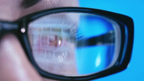 Reflective Work: Woman's Computer Display Visible Through Her Glasses at Dusk Stock Footage 293300971